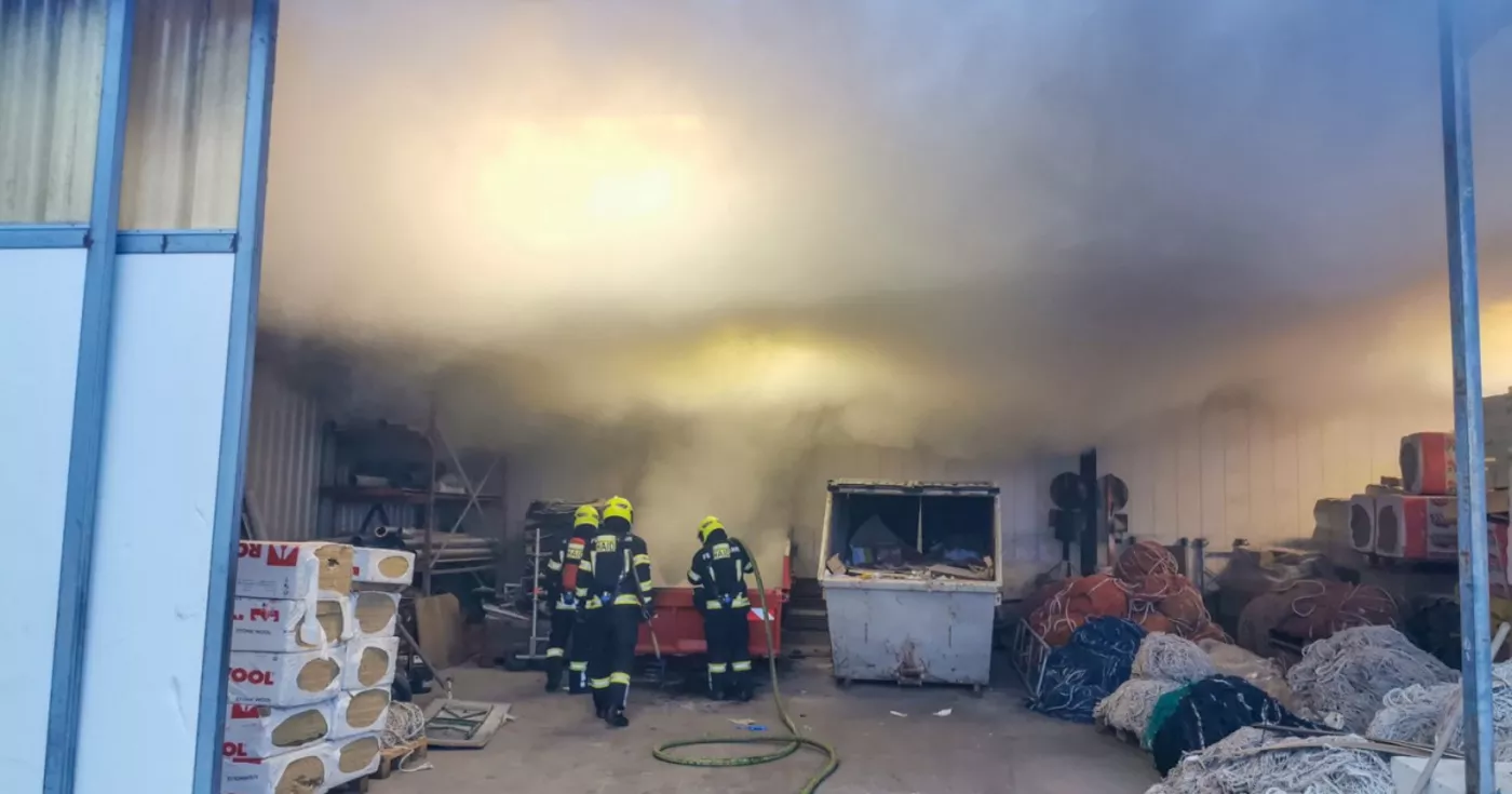 Titelbild: Abfallcontainer in einer Lagerhalle in Flammen